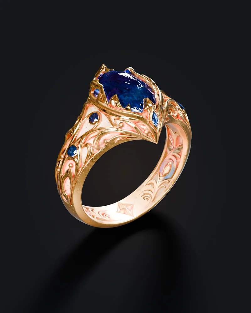A gold ring seen from above, its large deep-blue gemstone held in a pronged setting with filigree shoulders.